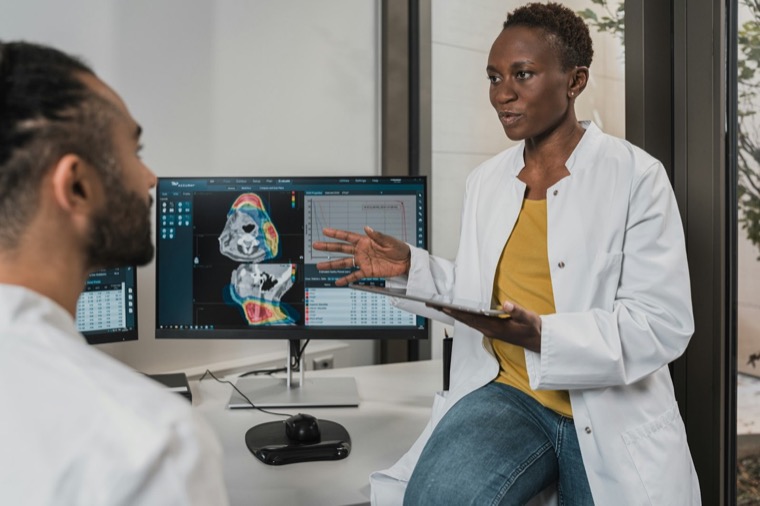Dos profesionales de salud revisando imágenes médicas en una pantalla